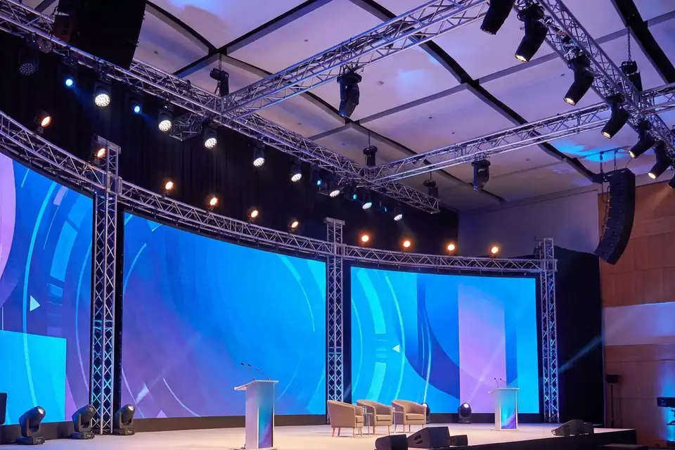 Illustration: a panel stage with LED walls, truss towers and moving lights